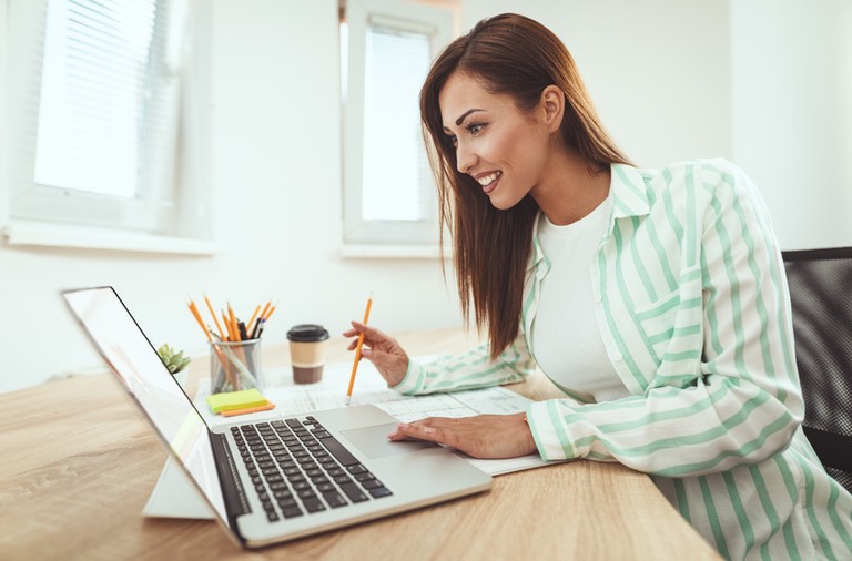 Woman learning blogging secrets on a laptop