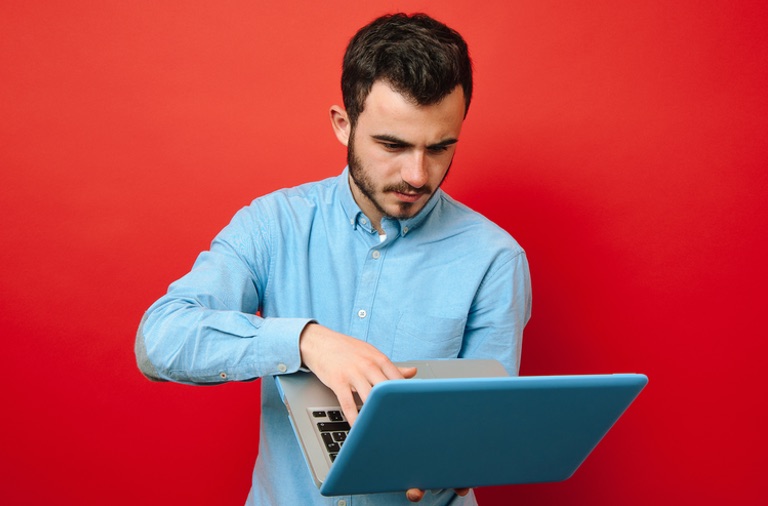 Young man on laptop working out how long it takes a blog to get noticed